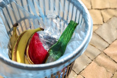Photo of Trash bag with garbage in bin outdoors, closeup