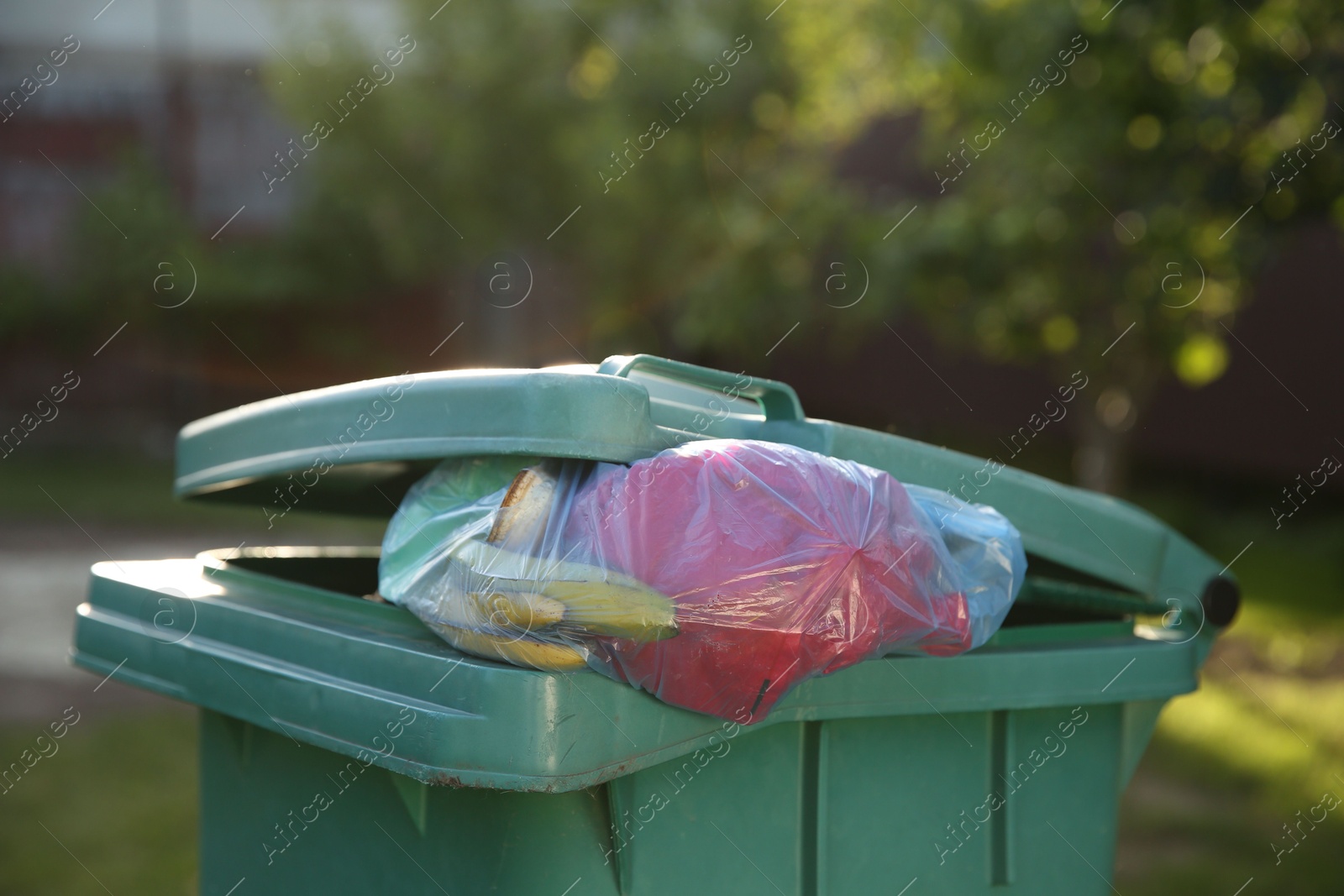 Photo of Trash bags full of garbage in bin outdoors, closeup