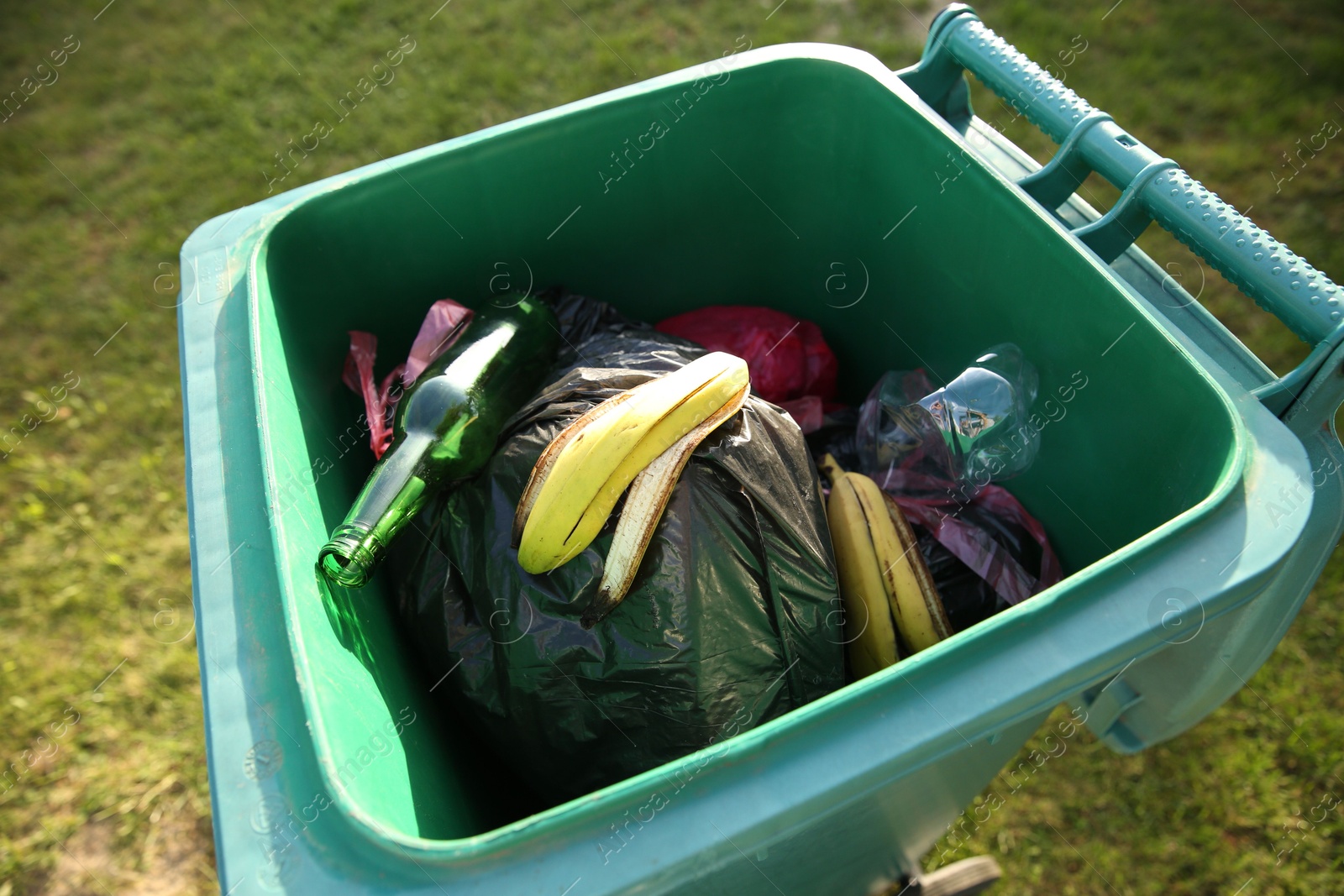 Photo of Trash bags full of garbage in bin outdoors, closeup