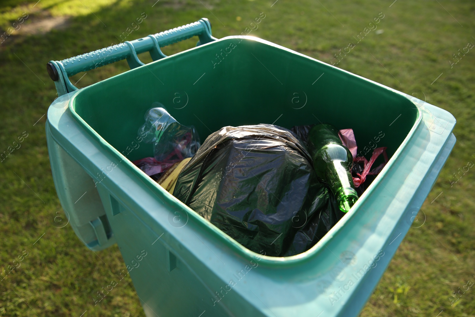 Photo of Trash bags full of garbage in bin outdoors, closeup