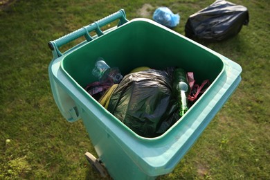 Photo of Trash bags full of garbage in bin outdoors, closeup