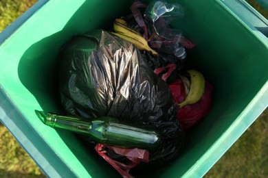 Photo of Trash bags full of garbage in bin outdoors, top view