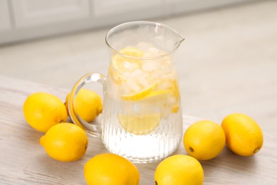 Photo of Freshly made lemonade in jug on white wooden table