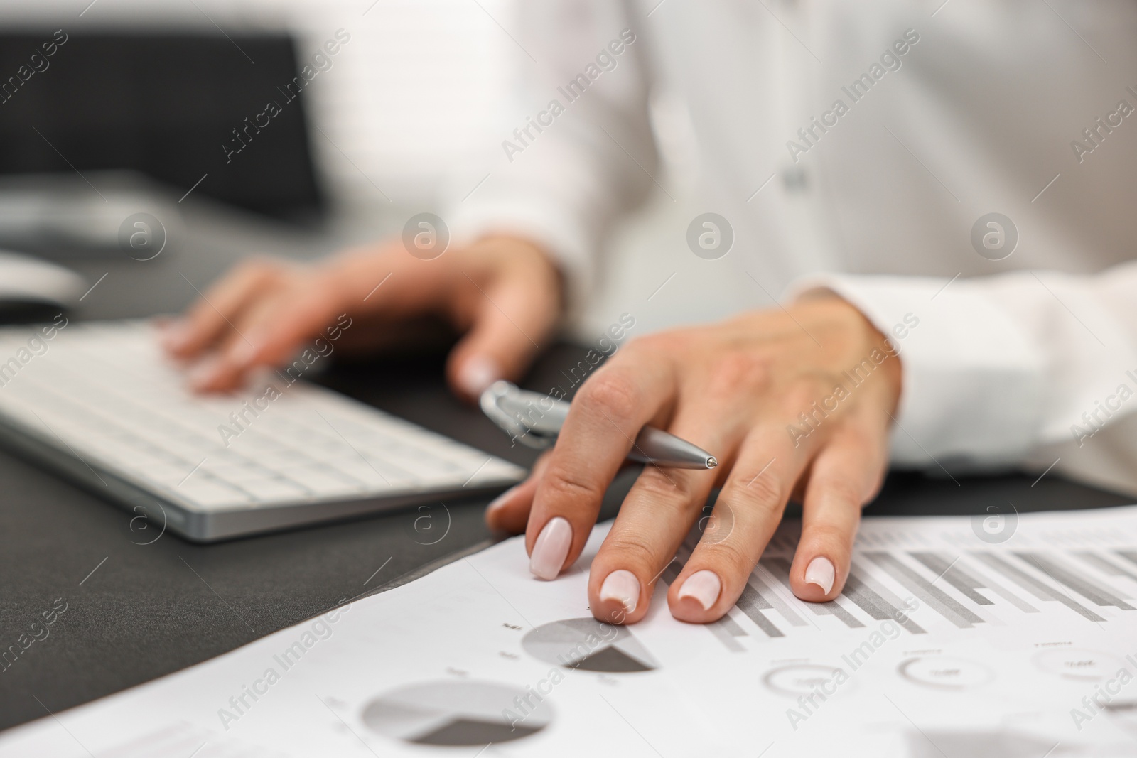 Photo of Secretary working with document at table in office, closeup