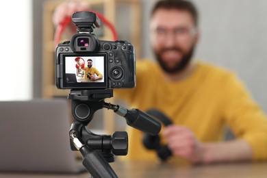 Technology blogger explaining something while recording video at home, focus on camera