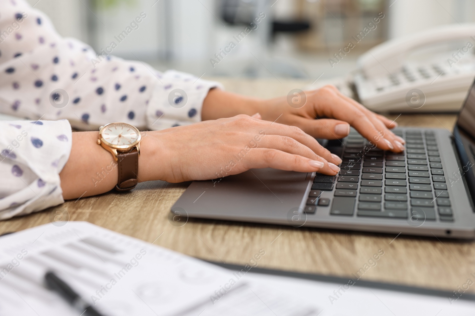 Photo of Secretary working with laptop at table in office, closeup