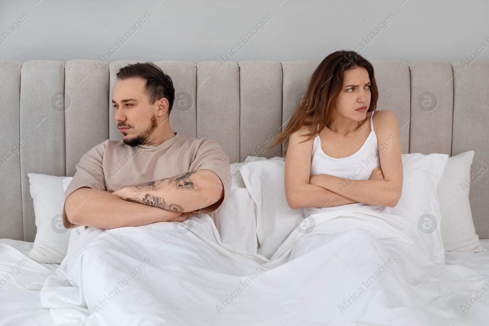 Photo of Offended couple after quarrel ignoring each other in bedroom. Relationship problem