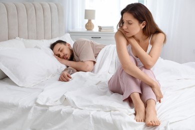 Offended couple after quarrel in bedroom. Relationship problem