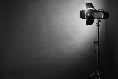 Dark photo background and professional lighting equipment in studio. Space for text