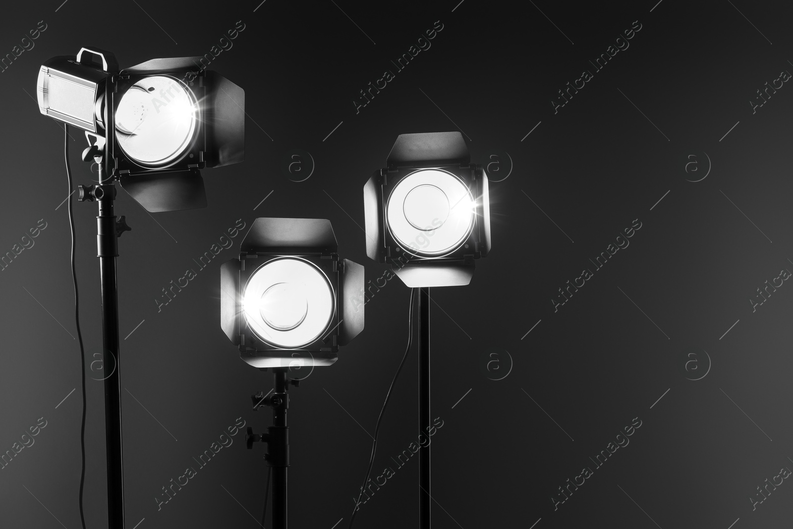 Photo of Dark photo background and professional lighting equipment in studio