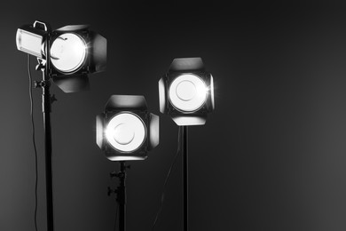 Photo of Dark photo background and professional lighting equipment in studio