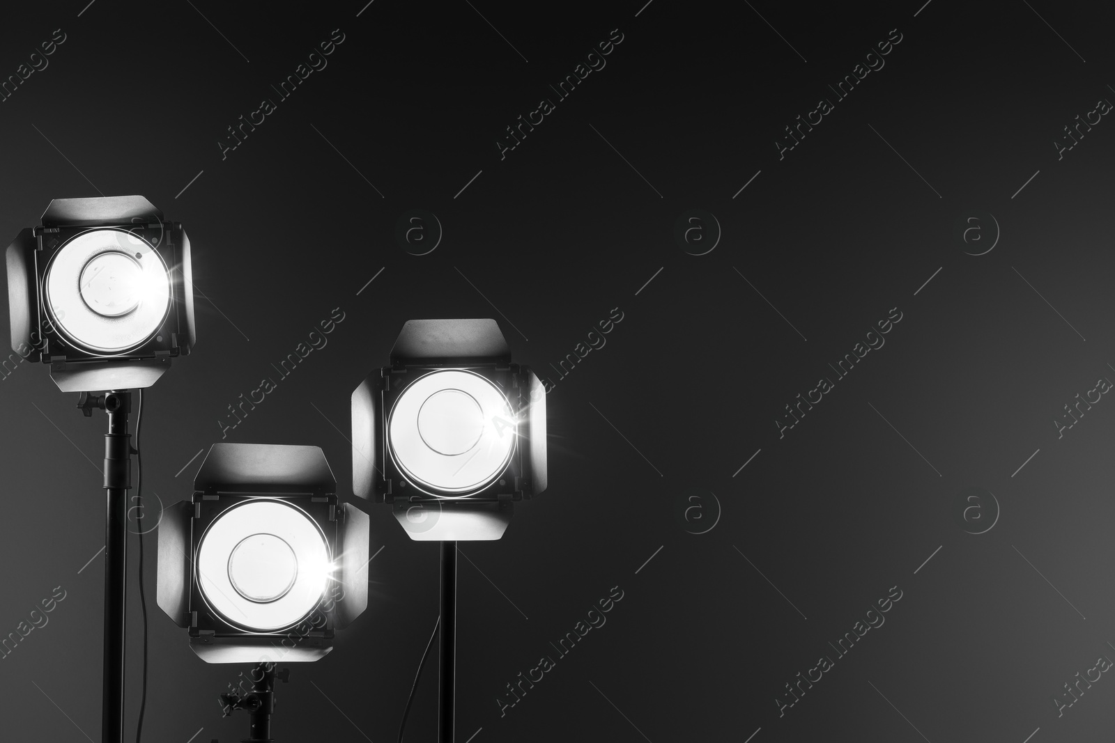 Photo of Dark photo background and professional lighting equipment in studio. Space for text