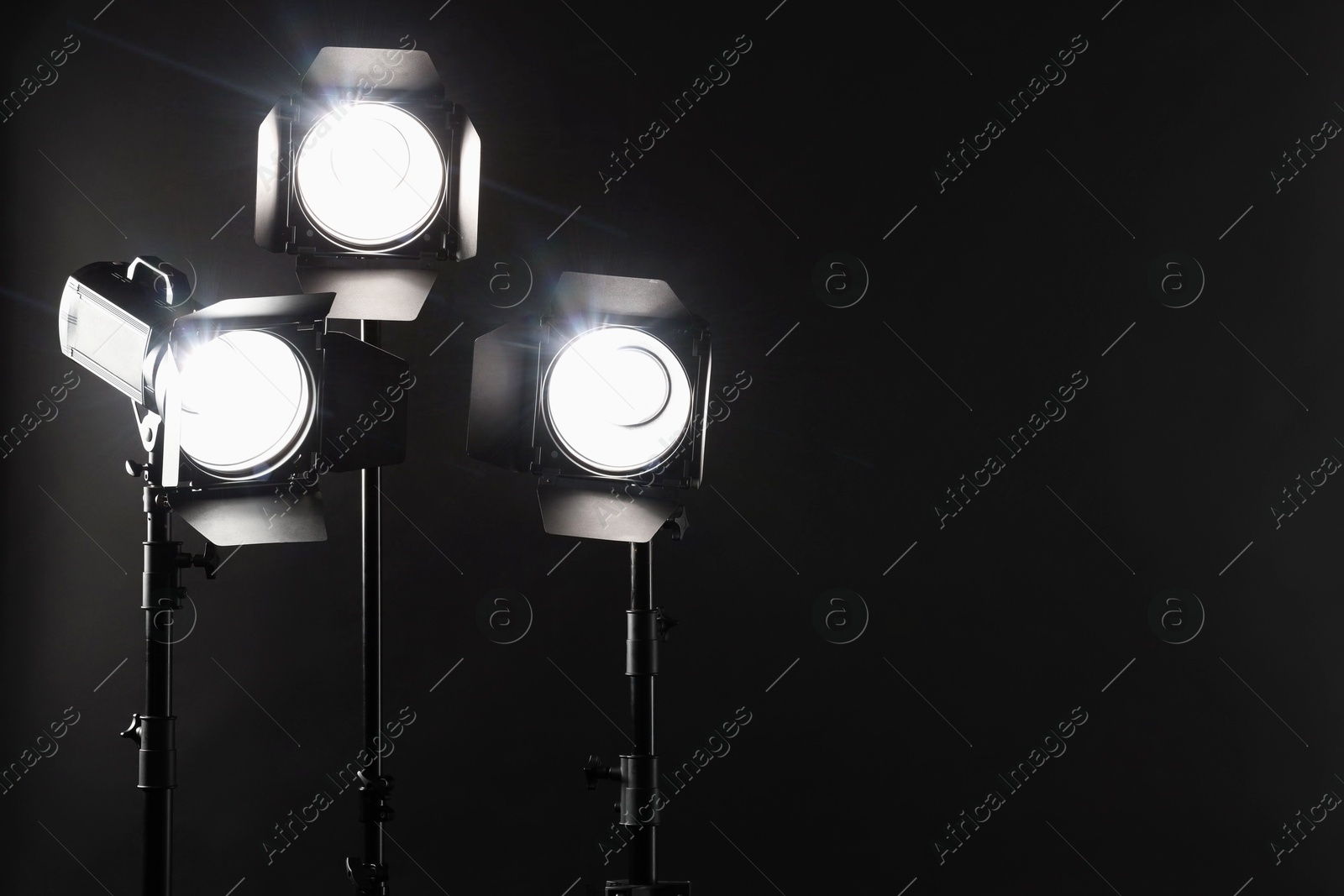 Photo of Dark photo background and professional lighting equipment in studio. Space for text