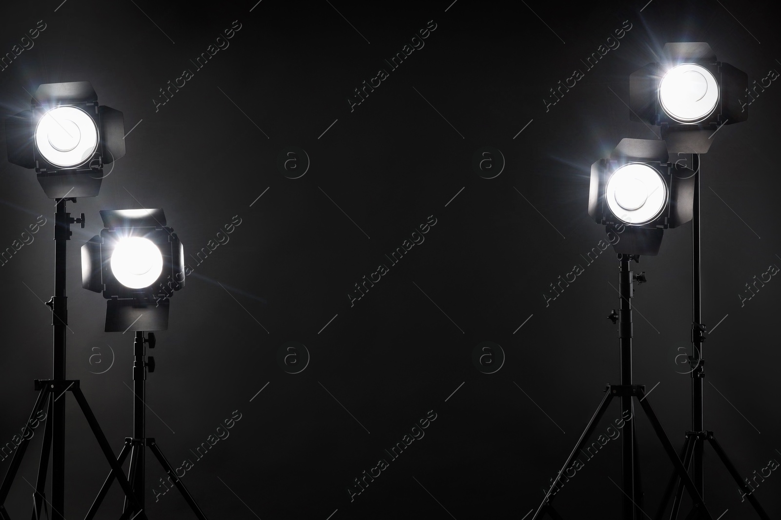 Photo of Dark photo background and professional lighting equipment in studio