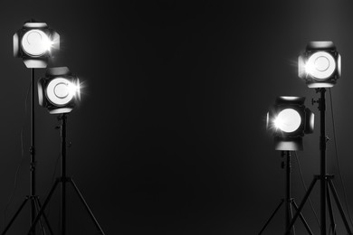 Dark photo background and professional lighting equipment in studio