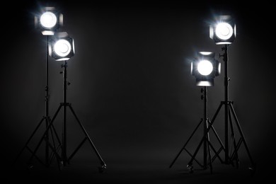 Dark photo background and professional lighting equipment in studio
