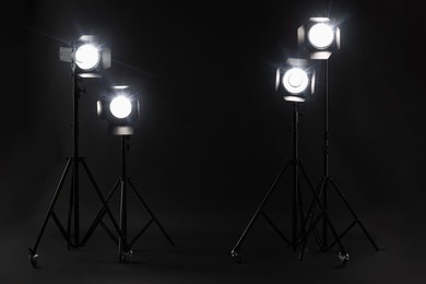 Dark photo background and professional lighting equipment in studio