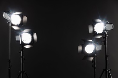 Dark photo background and professional lighting equipment in studio