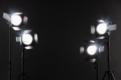 Photo of Dark photo background and professional lighting equipment in studio