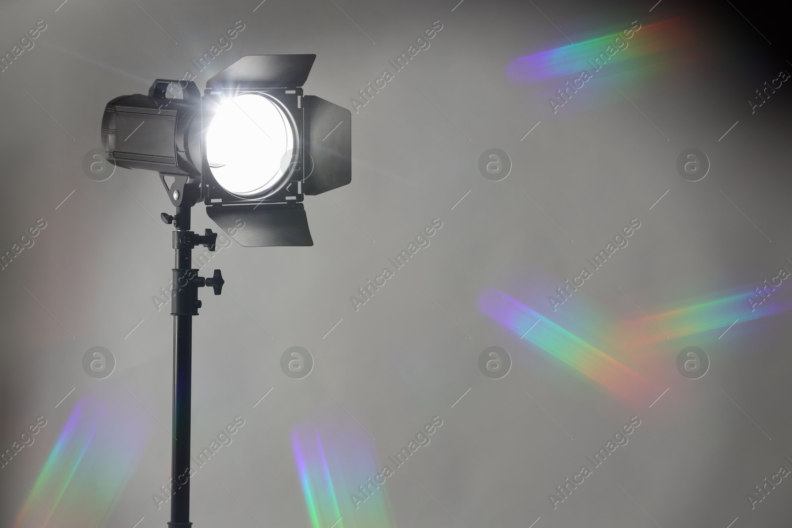 Photo of Grey photo background and professional lighting equipment in studio. Space for text