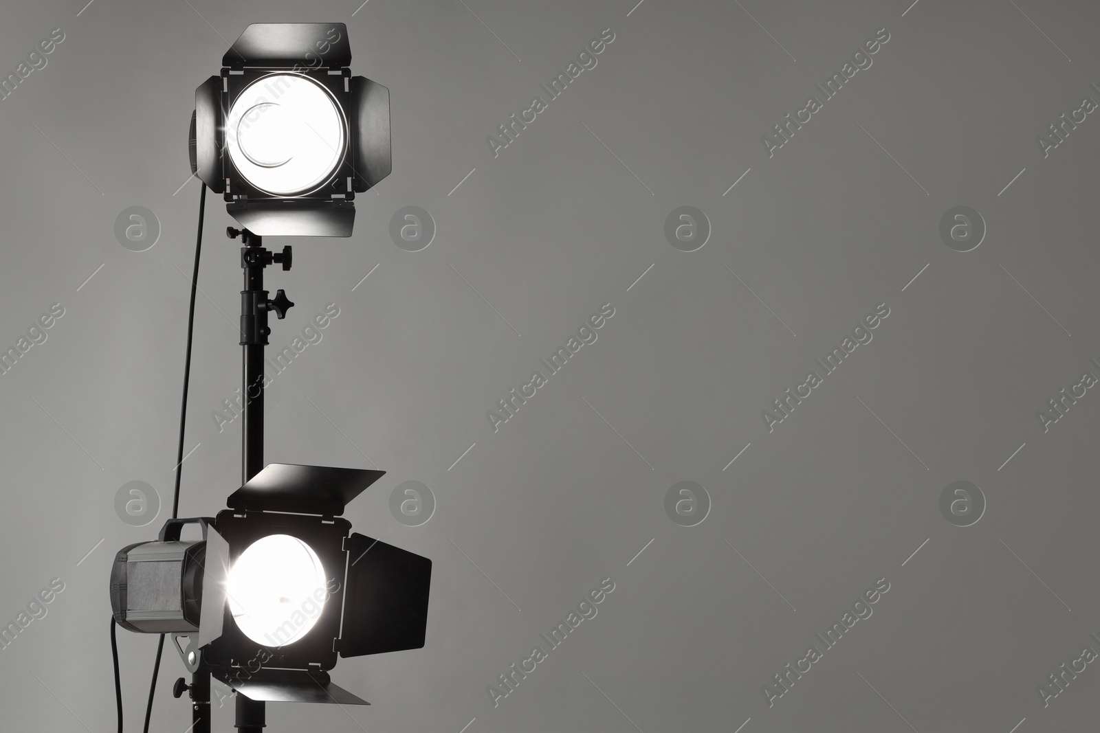 Photo of Grey photo background and professional lighting equipment in studio. Space for text