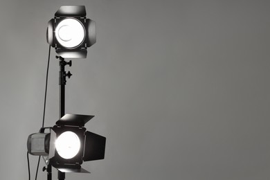 Grey photo background and professional lighting equipment in studio. Space for text