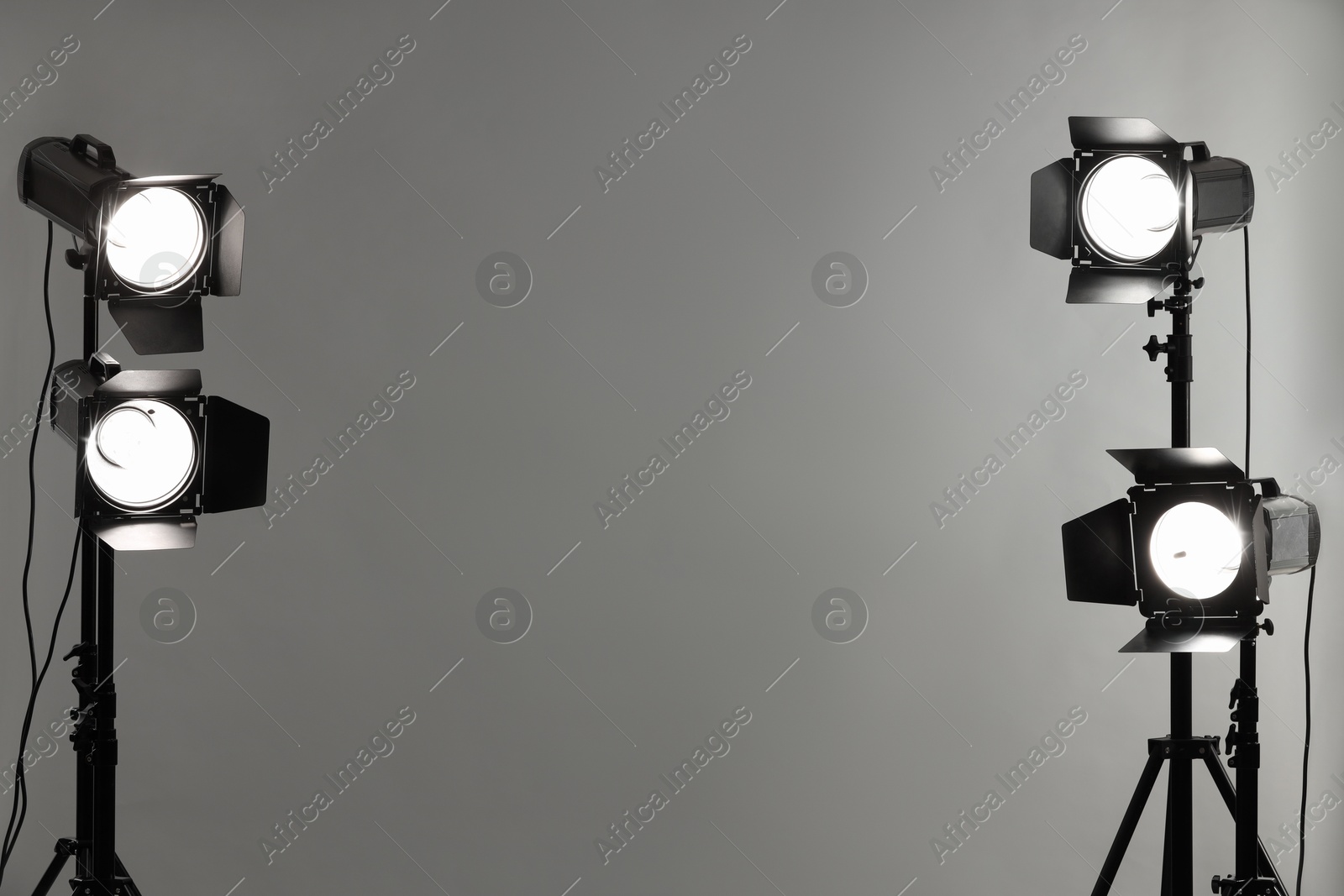 Photo of Grey photo background and professional lighting equipment in studio