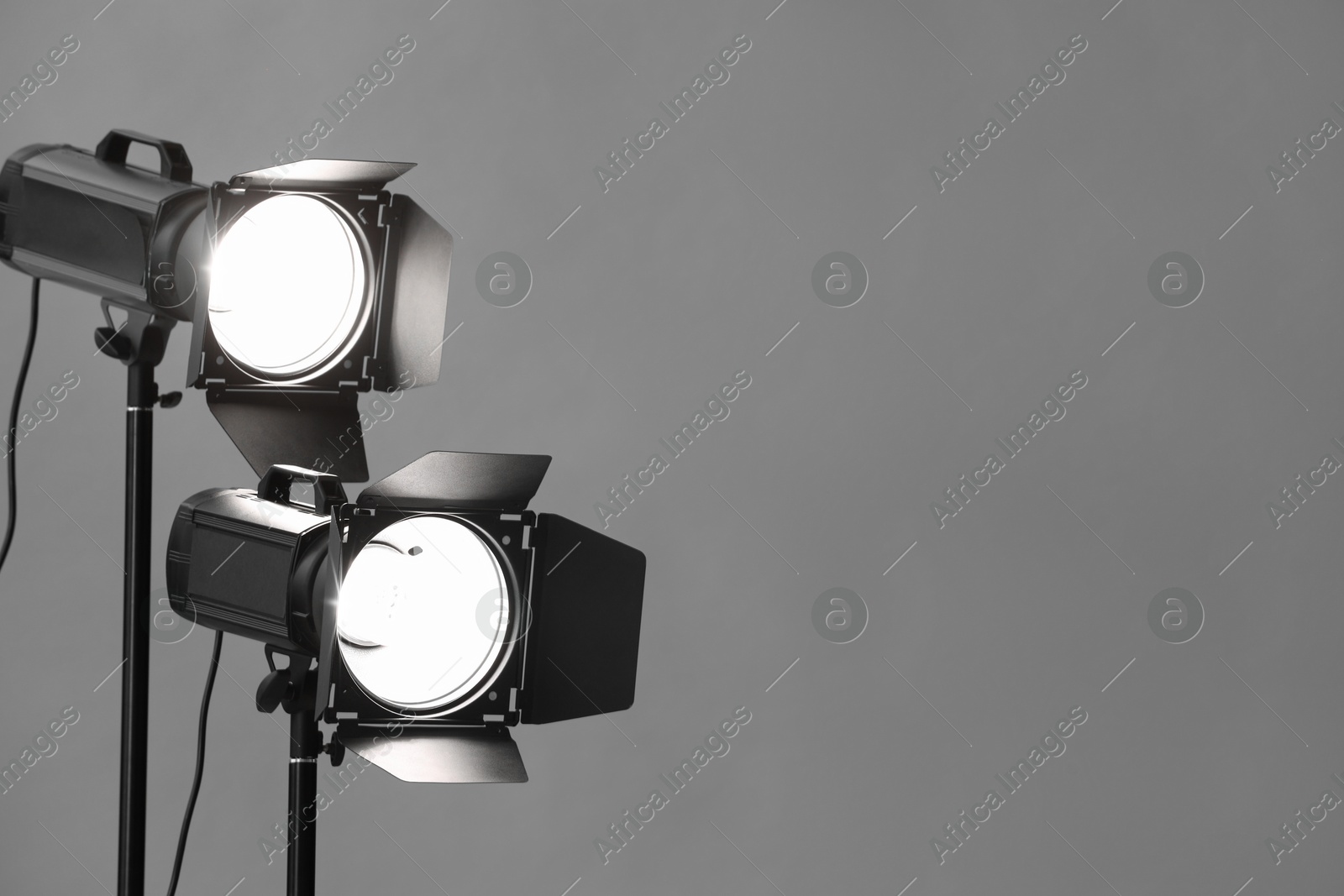 Photo of Grey photo background and professional lighting equipment in studio. Space for text