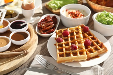 Photo of Different meals served for breakfast on wooden table