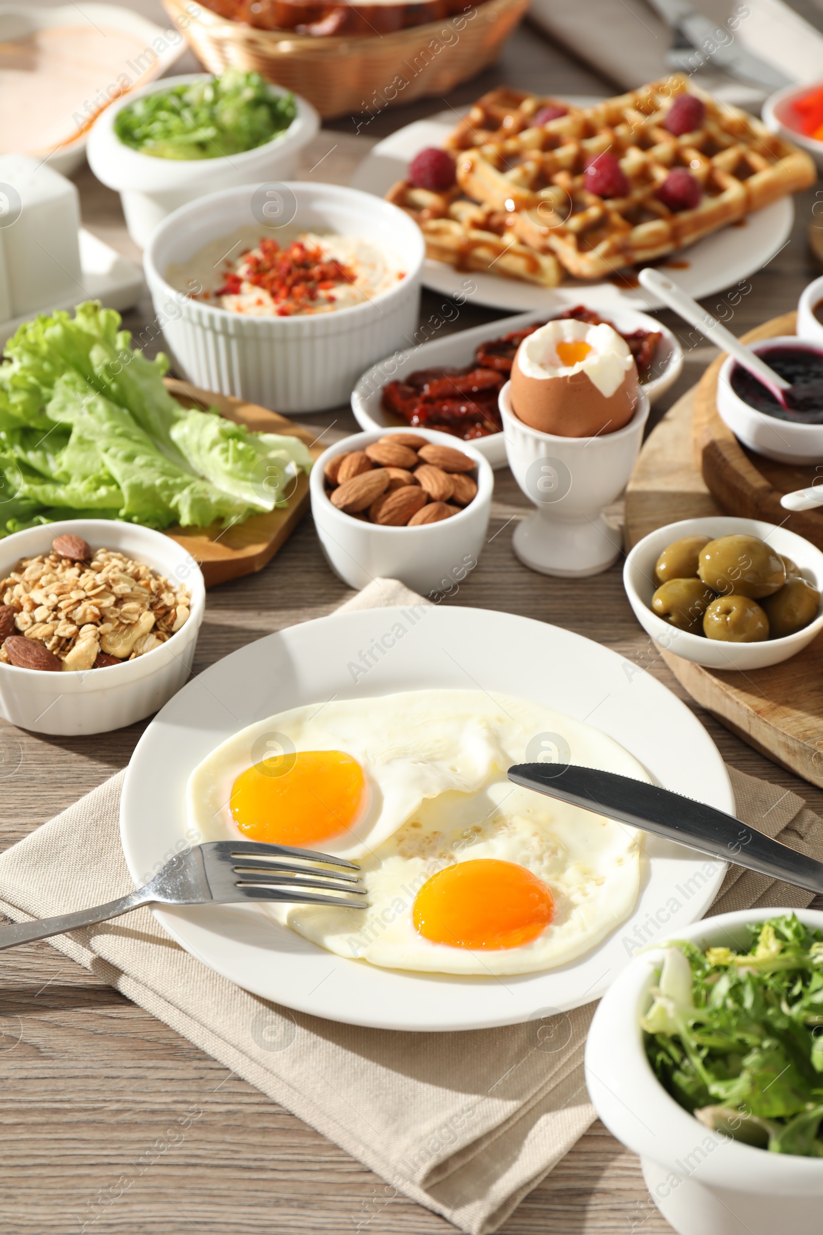 Photo of Different meals served for breakfast on wooden table