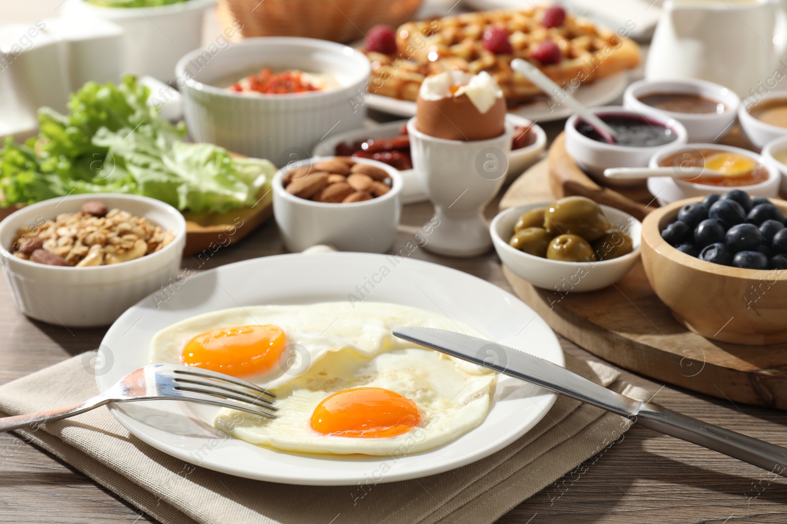 Photo of Different meals served for breakfast on wooden table