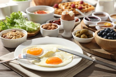 Photo of Different meals served for breakfast on wooden table