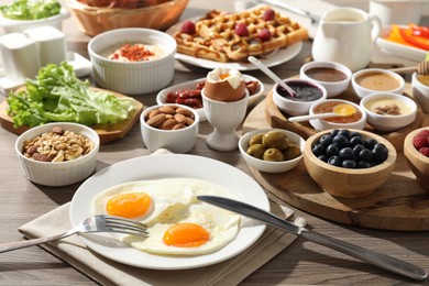 Photo of Different meals served for breakfast on wooden table