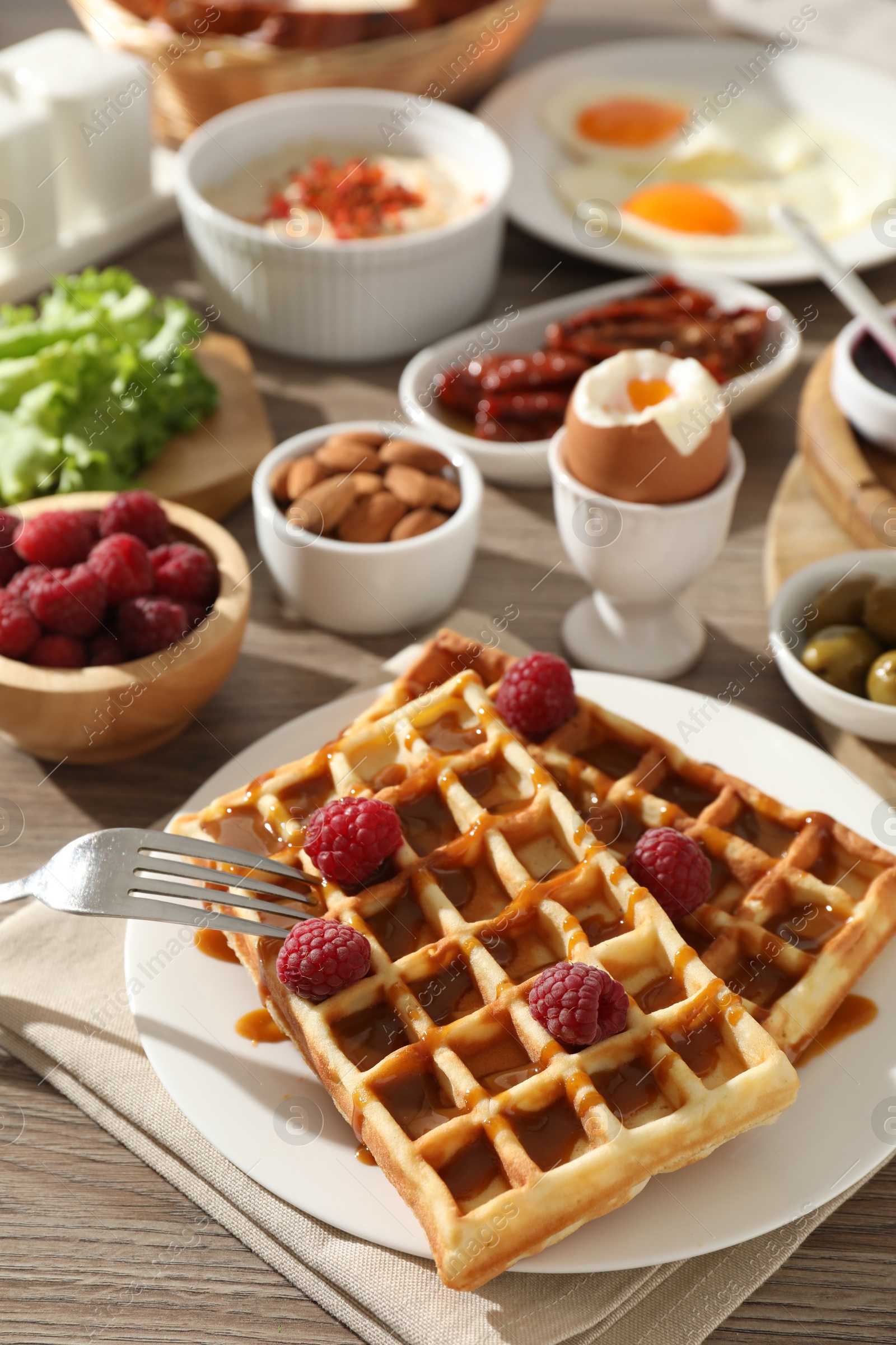 Photo of Different meals served for breakfast on wooden table