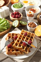 Photo of Different meals served for breakfast on wooden table