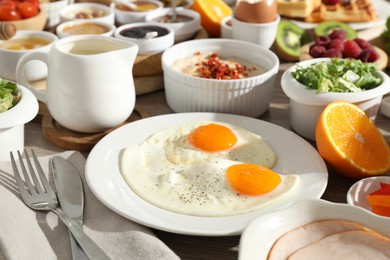 Photo of Different meals served for breakfast on wooden table