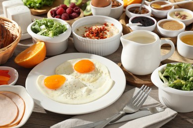 Photo of Different meals served for breakfast on wooden table