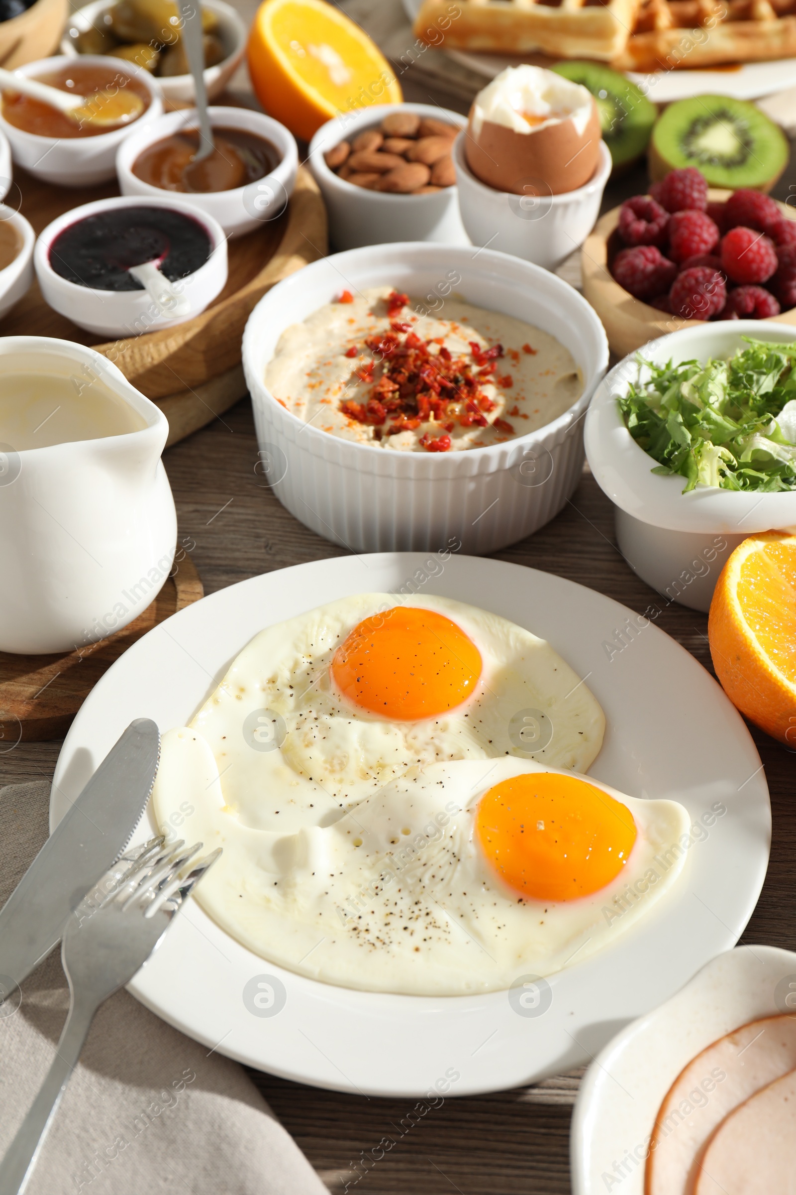 Photo of Different meals served for breakfast on wooden table