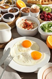 Photo of Different meals served for breakfast on wooden table