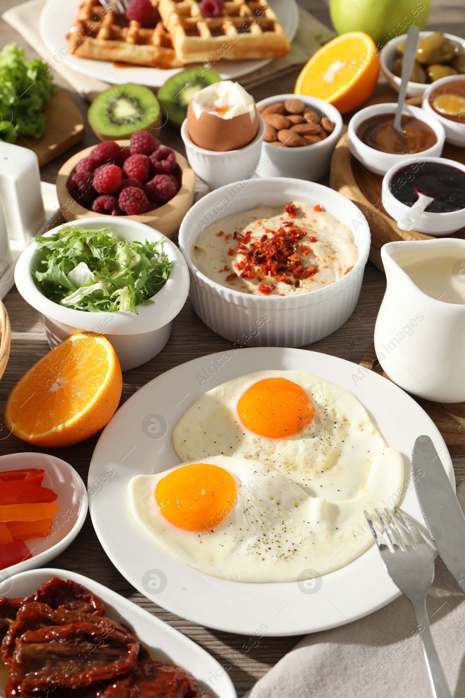 Photo of Different meals served for breakfast on wooden table