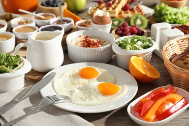 Different meals served for breakfast on wooden table