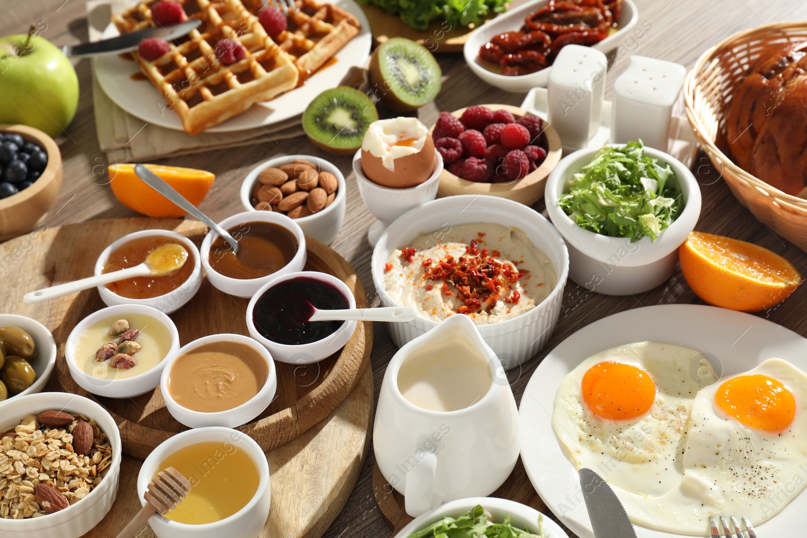 Photo of Different meals served for breakfast on wooden table