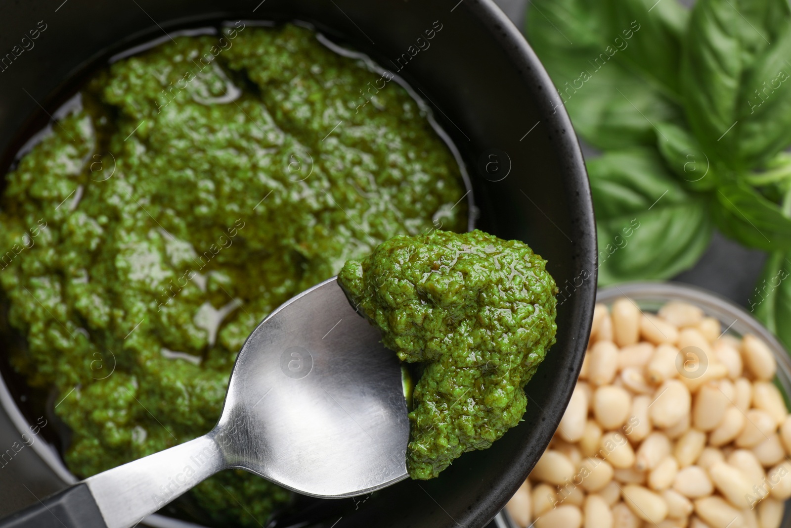 Photo of Taking tasty pesto sauce at table, top view