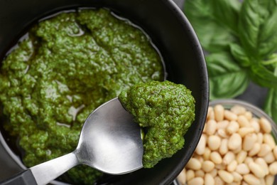 Photo of Taking tasty pesto sauce at table, top view