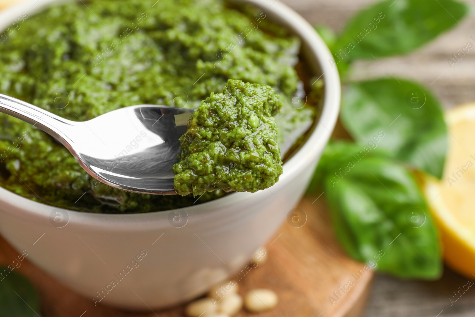 Photo of Taking tasty pesto sauce at table, closeup