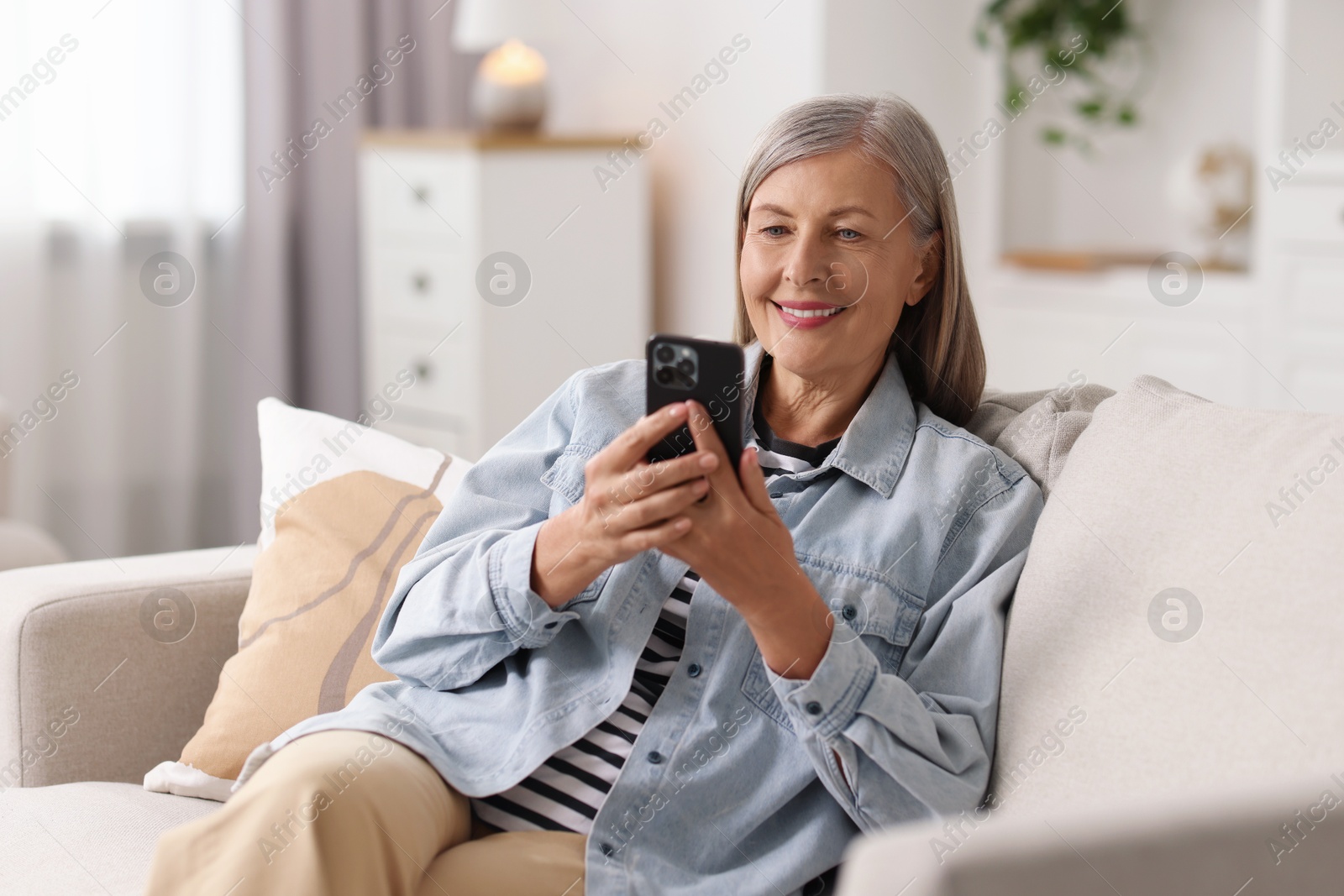 Photo of Senior woman using mobile phone at home