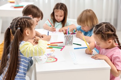 Group of children drawing at table indoors