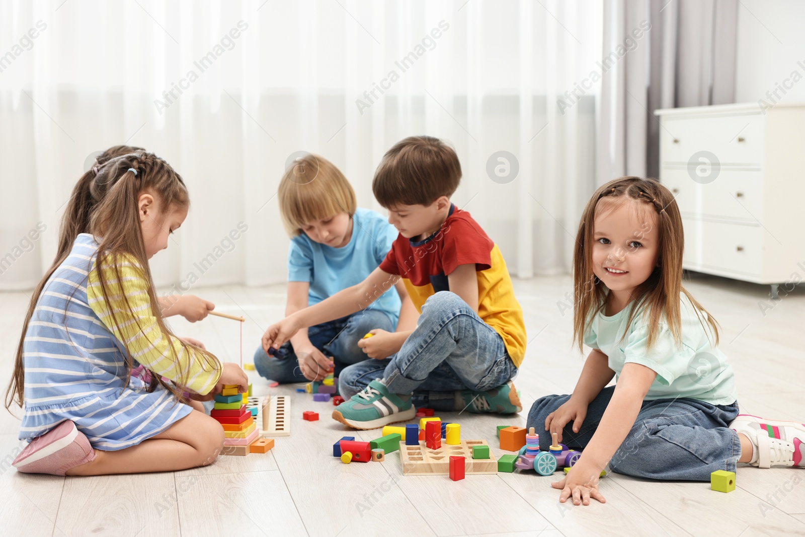 Photo of Group of children playing together on floor indoors