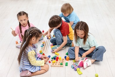 Group of children playing together on floor indoors