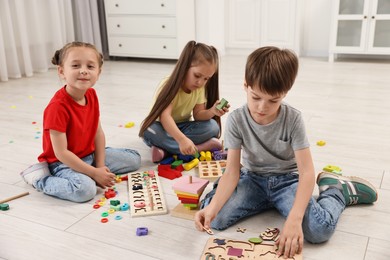 Cute little children playing together on floor indoors